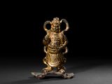 une figurine en or représentant une personne tenant un serpent