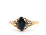 a close up of a gold ring with a blue stone