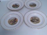 four plates with birds painted on them are sitting on a table
