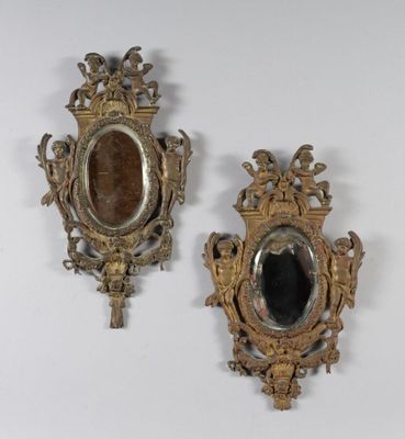 paire de miroirs en or richement décorés, avec un miroir ovale noir au centre