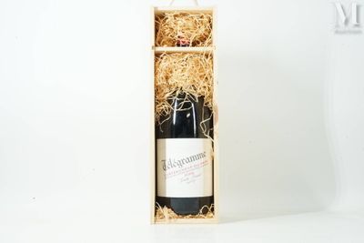 the bottle of wine is in a wooden box on a white surface