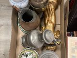 une boîte remplie d'objets en argent et en or posée par terre