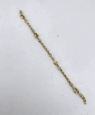 a close up of a gold chain bracelet with a heart on it