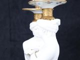 a white and gold vase with a bird on top of it