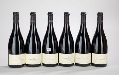 six bouteilles de vin sont alignées sur une table