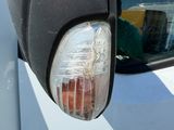 un gros plan du rétroviseur latéral d'une voiture, dans lequel on voit le reflet d'une personne