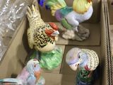 many figurines of birds in a box on the floor
