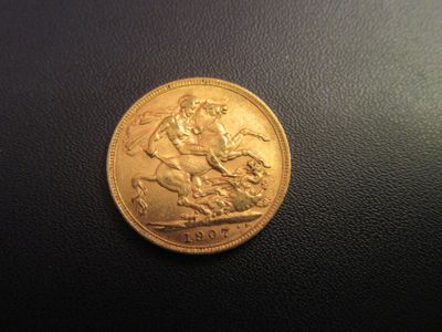gros plan d'une pièce d'or sur une surface noire
