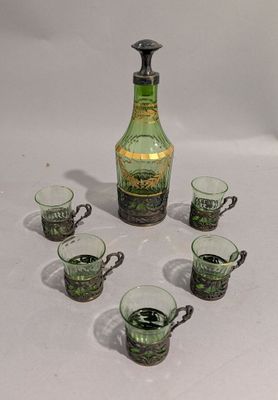 des bouteilles et des tasses sont disposées en cercle sur une surface blanche