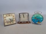 three clocks sitting next to each other on a table