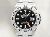 une montre Rolex avec un cadran noir et un bracelet en acier inoxydable