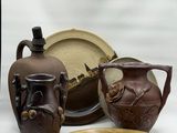 three vases, a plate, and a bowl sitting on a table