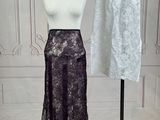 two skirts on a mannequin stand in front of a white wall