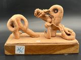 a clay sculpture of a man and a woman on a bench