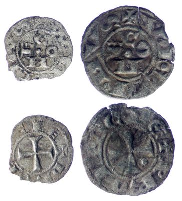 quatre pièces d'argent ornées de symboles, notamment une croix et un lion