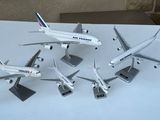 cinq maquettes d'avions posées sur une table blanche