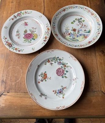 three plates on a wooden table with flowers on them