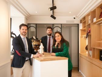 trois personnes debout derrière un comptoir dans une pièce