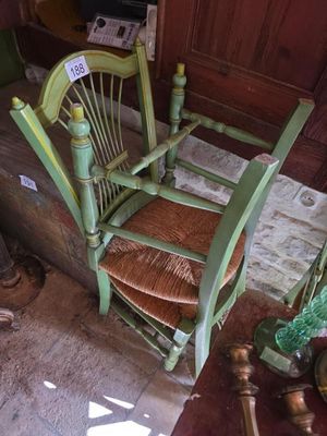 a green rocking chair sitting in the corner of a room