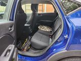 a blue car with a bunch of items in the back seat