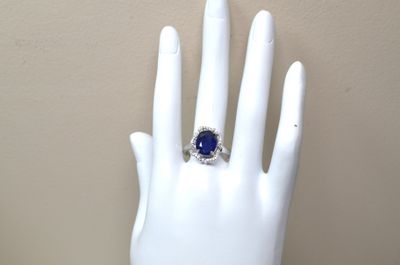 une main sur laquelle est passée une bague sertie d'une pierre bleue