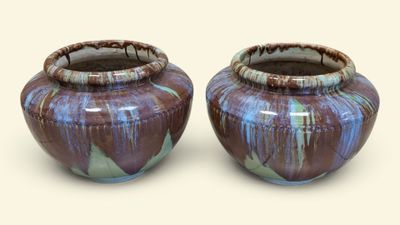 two vases sitting next to each other on a white surface