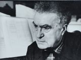 black and white photograph of a man sitting at a piano