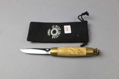 a knife that is laying on a table next to a pouch