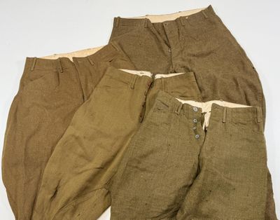 Trois paires de pantalons pour homme sont alignées sur une surface blanche