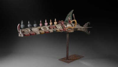 une photo d'une sculpture représentant un poisson surmontée de bougies