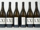 six bouteilles de vin sont alignées sur une table