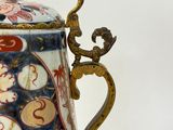 a small vase with a handle on a white surface