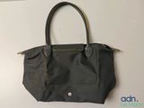 a black purse hanging on a wall with a white background