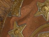 a brown vase with gold stars on it on a wooden table