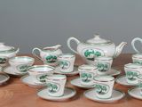 a collection of porcelain tea and coffee sets on a wooden table