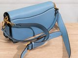 the small blue bag is sitting on a wooden table