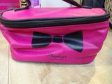 the pink bag has a black bow on it