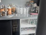 a small kitchen with a refrigerator, dishwasher, and other items on the counter