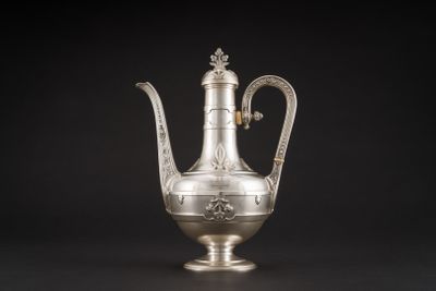 une cafetière ancienne en argent avec une anse, sur fond noir