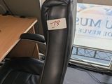 a black office chair sitting in front of a window