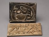 a bronze plaque with a bird and a fish on it