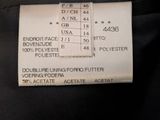 a label on the back of a black jacket