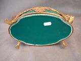 a green tray with a gold decoration on top of it