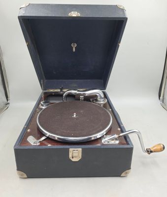 un vieux tourne-disque posé dans une valise sur une table