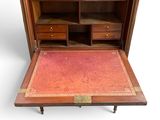 a small wooden desk with a red rug on the floor