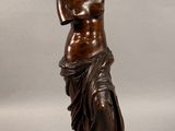 statue en bronze représentant une femme tenant une fleur à la main