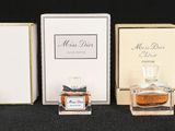 four bottles of perfume are lined up in a row on a black surface