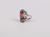 a close up of a silver ring with an orange stone on it