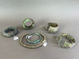 several different types of rings and bracelets are displayed on a table