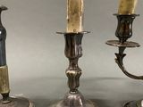 two silver candles are sitting on a table next to each other